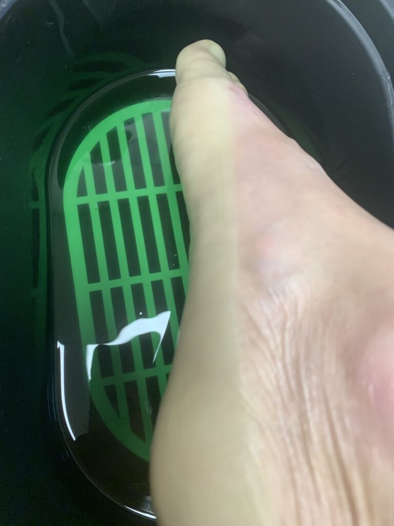 11 Abi Tervisekabinetis on kliendi jalad kastetud soojaparafiini sisse ja vannist välja võttes moodustab see rohelise parafiini kihi jalgadele.