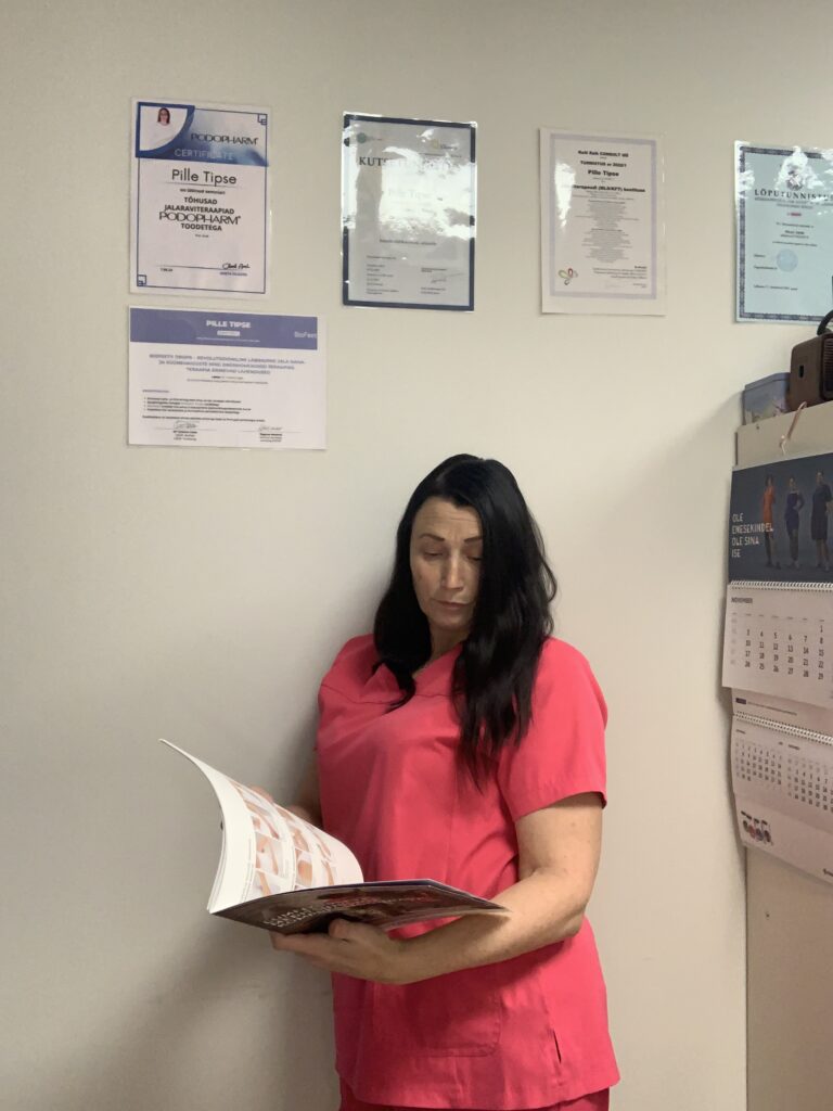 11 Abi omanik uurimas komressioontoodete kataloogi.Taustal näha diplomid ja kalender.